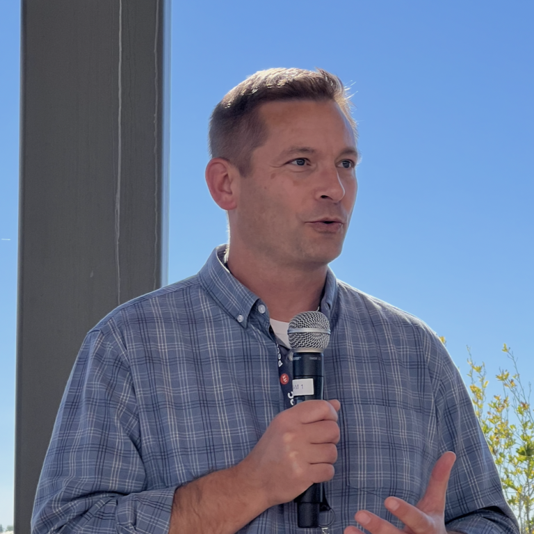 Pastor Jason Hudson speaking into a microphone